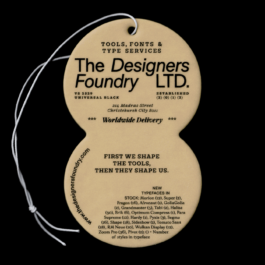 A beige, figure-eight-shaped air freshener tag with black text, designed to promote The Designers Foundry LTD., a company specializing in tools, fonts, and type services. The front features their address in Christchurch, New Zealand, the phrase 