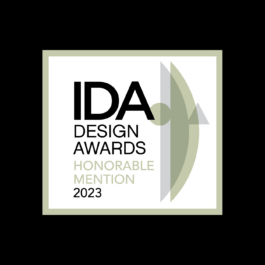 Logo of the IDA Design Awards 2023 featuring the text 'IDA Design Awards Honorable Mention 2023'. The text is set against a white background with a light green border and a geometric abstract shape overlapping the right side of the text. The word 'HONORABLE MENTION' is in light green, while the rest of the text is in black. Filippos Fragkogiannis