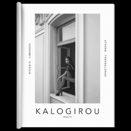 A fashion magazine spread featuring a black-and-white photograph of a woman sitting in an open window, wearing a stylish outfit with high heels. The architecture surrounding the window has classic decorative details. The brand name 